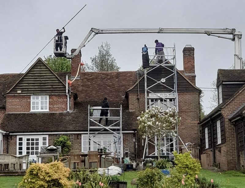 The Moss Cleaners using cherry picker and scaffolding to clean roof safely and professionally in 111 High St, Feltham TW13 4HG, UK, 111 High St, Feltham TW13 4HG, UK